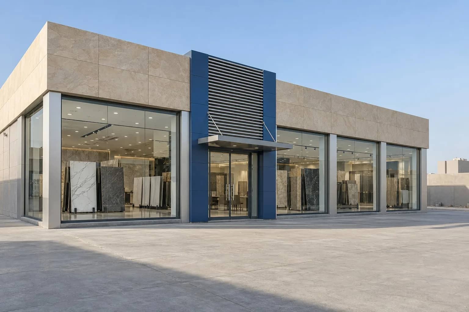 Illustration: Single-storey showroom with beige stone cladding, a blue louvred entrance and glass bays showing marble and tile slabs on display